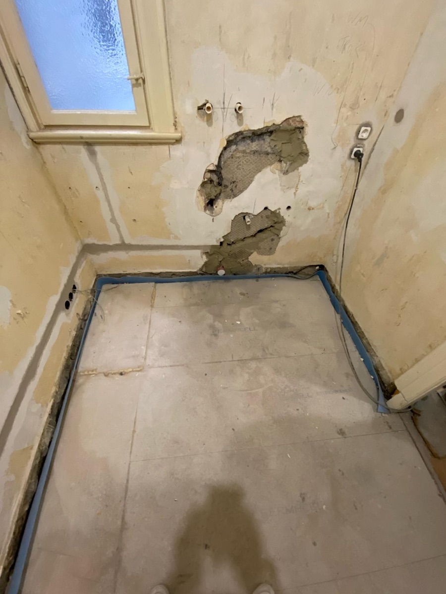 Hauswirtschaftsraum im Rohbau mit aufgestemmter Wand vor der Sanierung